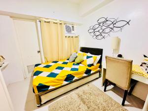 a bedroom with a bed with a yellow and blue comforter at Tagaytay Staycation - Casa Editha in Tagaytay +7 photos