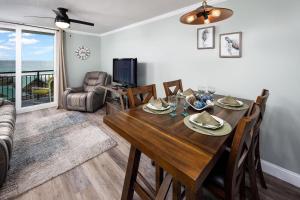 comedor con mesa, sillas y TV en Nautilus 2509 Gulf View 2 Bedroom 5th Floor Free Beach Service, en Fort Walton Beach