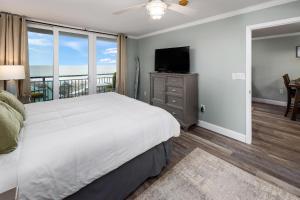 1 dormitorio con cama, TV y balcón en Nautilus 2509 Gulf View 2 Bedroom 5th Floor Free Beach Service, en Fort Walton Beach
