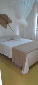 1 dormitorio blanco con 1 cama y ventilador en Morena Flor Cabana, en Angra dos Reis