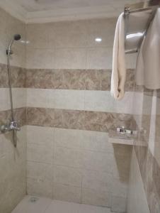 La salle de bains est pourvue d'une douche avec une porte en verre. dans l'établissement Alamsagita Puncak Hotel & Resort, à Ciloto