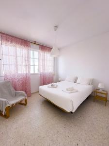 桑盧卡爾－德巴拉梅達的住宿－Magnífico dúplex de 3 dormitorios con vistas a la playa，白色的卧室设有一张大床和一个窗户