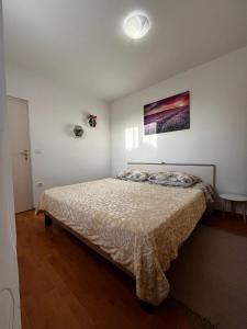 a bedroom with a bed and a painting on the wall at Apartman Mimi in Pula