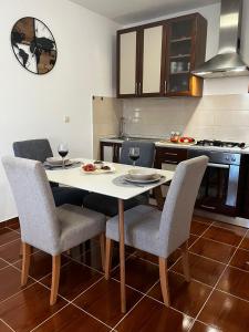 a kitchen with a table and chairs with wine glasses at Apartman Mimi in Pula