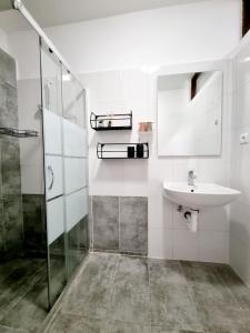 een witte badkamer met een wastafel en een douche bij Apartman Mimi in Pula