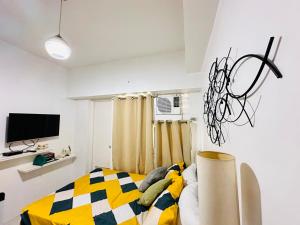 a bedroom with a bed with a yellow and black blanket at Tagaytay Staycation - Casa Editha in Tagaytay