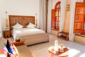 a bedroom with a bed and a table in a room at Riad Al Ansari in Fez