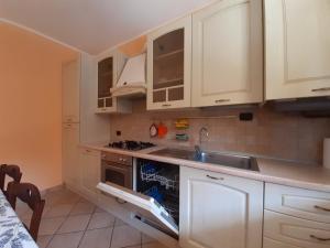 una cocina con armarios blancos y fregadero en I Tre Aceri, en Magreglio
