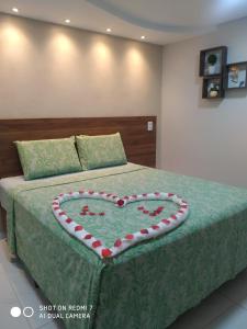 uma cama com uma almofada em forma de coração em Pousada Beija Flor em Maceió