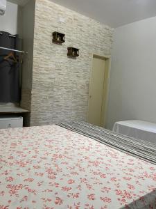 1 dormitorio con cama y pared de ladrillo en Pousada Beija Flor en Maceió