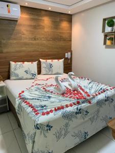 Una cama con dos cisnes en una habitación en Pousada Beija Flor en Maceió