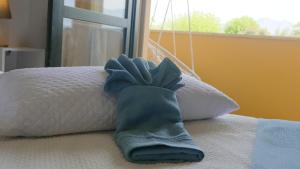ein blauer Handschuh, der auf einem Bett liegt in der Unterkunft Appartamento [Golden Hour] Marina di Pietrasanta in Marina di Pietrasanta