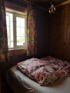 1 dormitorio con 1 cama y una ventana con cortinas en Villa Fjara, en Ulven