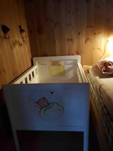 a white crib with a sign on it next to a bed at Villa Fjara sleeps 22 in 6 bedrooms in Ulven +35 photos