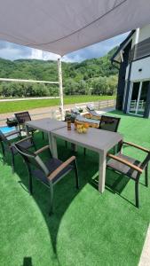 a picnic table and chairs on the grass at Vikendica River Drina - Mali Zvornik-Velika Reka in Podrebelj