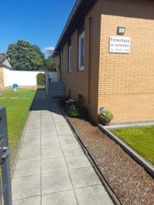 a sidewalk next to a building with a sign on it at Ferienhaus Nr.7 in Winsen Aller