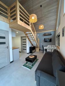 a living room with a couch and a table at Na Zaciszu - apartament z jacuzzi in Szczytna