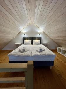 a bedroom with a bed with two towels on it at Na Zaciszu - apartament z jacuzzi in Szczytna