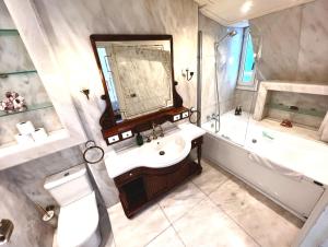 a bathroom with a sink and a tub and a mirror at Far Out Inn - Yoga guesthouse in San Sebastián