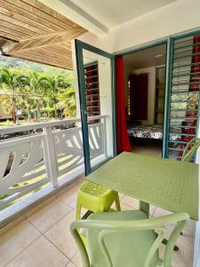 波拉波拉的住宿－Studio entre lagon et montagne，阳台上配有绿色的桌椅