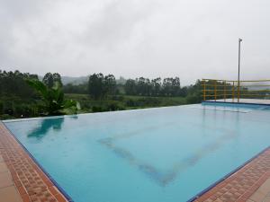 聖羅莎德卡瓦爾的住宿－Finca El Ovito，一座大型蓝色游泳池,位于一座建筑的顶部