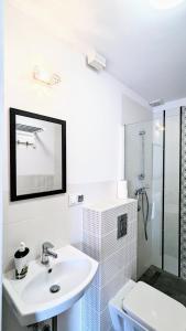 a white bathroom with a sink and a toilet at ISLAND4U in Gdańsk