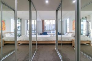 two beds in a room with mirrors at Close to everything Family Friend 2 Free Parking in Sydney