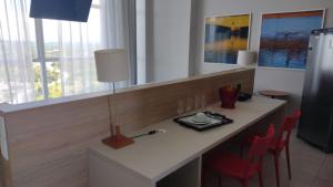 a room with a desk with chairs and a lamp at Paiva Flats By Loui in Recife