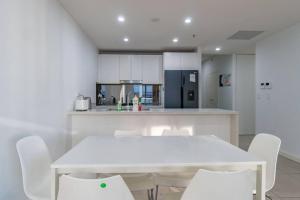 a kitchen with a white table and white chairs at Close to everything Family Friend 2 Free Parking in Sydney