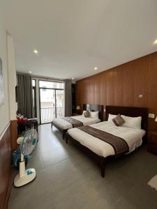 a bedroom with two beds and a fan in it at Kha Hostel in Hue +67 photos