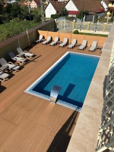- une piscine avec des chaises longues sur une terrasse dans l'établissement Regal Beius, à Beiuş