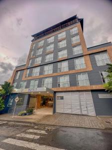 a large building with a garage in front of it at VVC Hotel's in Villavicencio