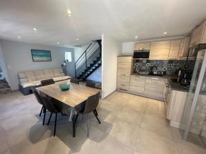a kitchen and dining room with a table and a couch at GITES DE KERFETAN in Moréac