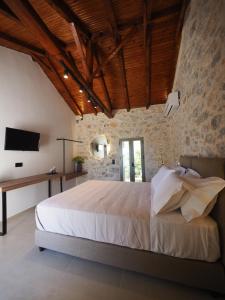 a bedroom with a large bed in a stone wall at Sophia Town Square Areopoli in Areopolis