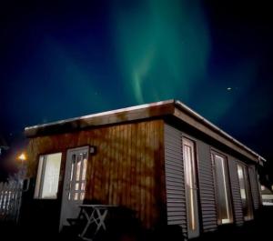 una cabaña con las luces del norte en el cielo en STUDIO AURORA, en Reikiavik