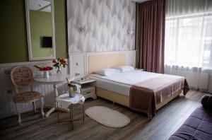 a bedroom with a bed and a table and a mirror at Sport Point Hotel in Khimki