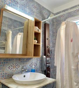 a bathroom with a sink and a mirror at Charme Bleue-Appartement Magique in Monastir