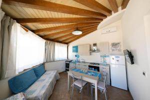 Il comprend un salon avec une table et une cuisine. dans l'établissement LOFT NICOLIZIA - Area Esterna Esclusiva con Vista Mare, à Licata