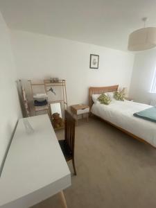 a room with two beds and a table and a desk at Torias Place - Lenham in Maidstone