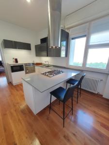 uma cozinha com uma ilha branca com um fogão e cadeiras em B&B Cremonese em Parma