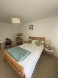 a bedroom with a large bed with white sheets at Torias Place - Lenham in Maidstone
