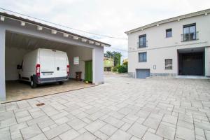 uma carrinha branca estacionada numa garagem ao lado de um edifício em B&B Cremonese em Parma