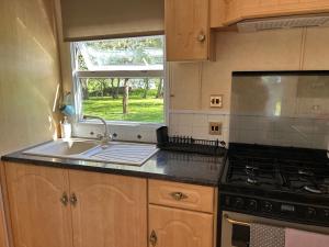 a kitchen with a sink and a stove and a window at Holiday Home Klavas in Sigulda