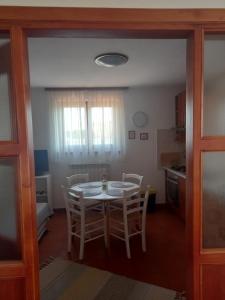 cocina y comedor con mesa y sillas en Apartments Leone, en Brtonigla
