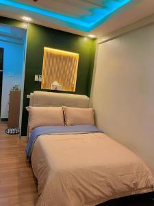 sypialnia z łóżkiem i zieloną ścianą w obiekcie Oppas Studio Unit near Sm uptown w mieście Cagayan de Oro
