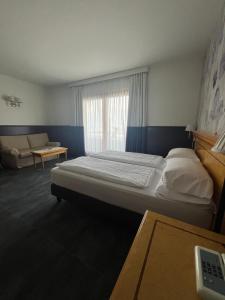 a bedroom with a bed and a couch and a window at Villa Selene in Tremosine Sul Garda