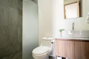 a bathroom with a white toilet and a sink at Centric Apartment, King Bed, Roof, Chapalita in Guadalajara