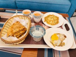 a tray with breakfast foods and two cups of coffee at Holidazzle Villa in Karachi