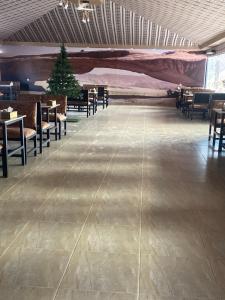 a dining hall with tables and chairs and a christmas tree at Omar Camp Wadi Rum in Disah