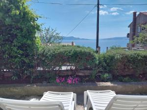 two white chairs and a view of the water at Apartman Seka in Senj